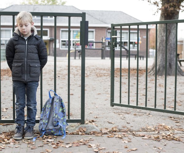 Boy outside school gates